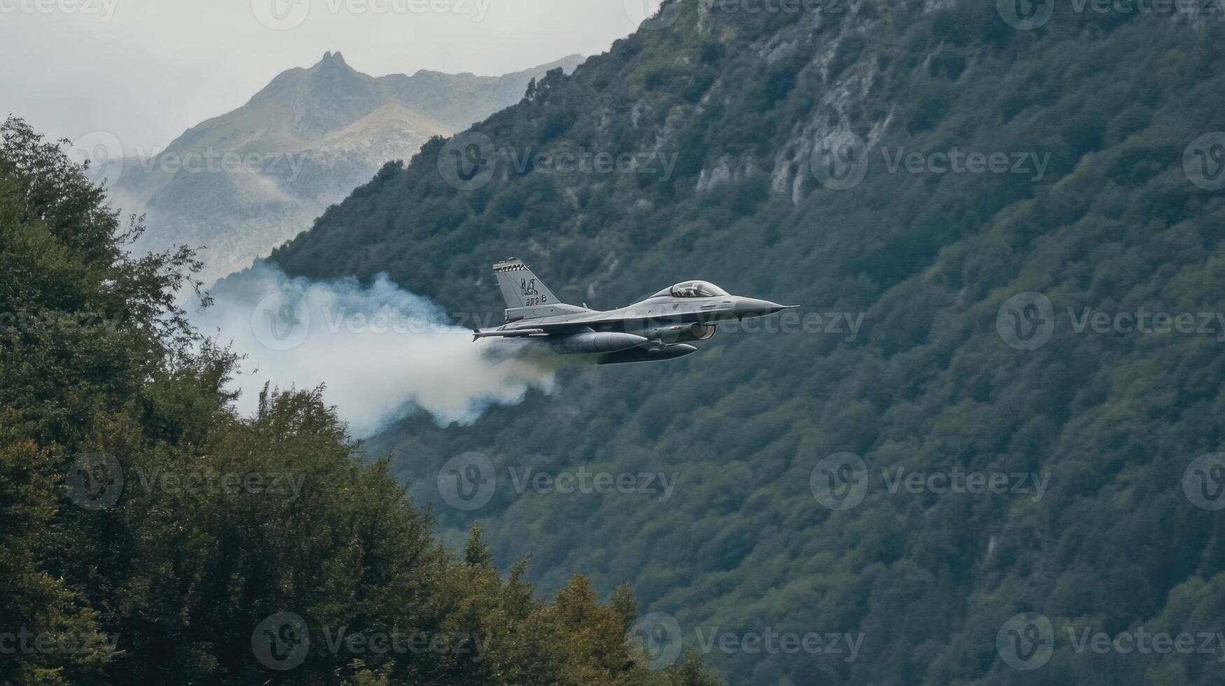 Jet Airplane Soars Through Mountain Valley with Aerial Acrobatic Maneuvers and Vapor Trails. Flight, Aviation, Aircraft. photo