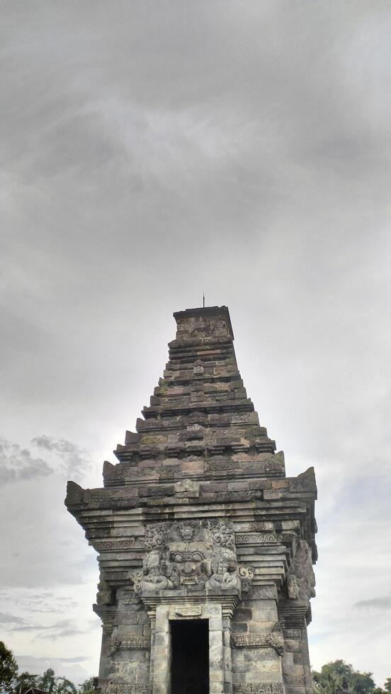 Ancient Stone Temple Against Cloudy Sky, Architectural Detail, Vertical Composition. photo