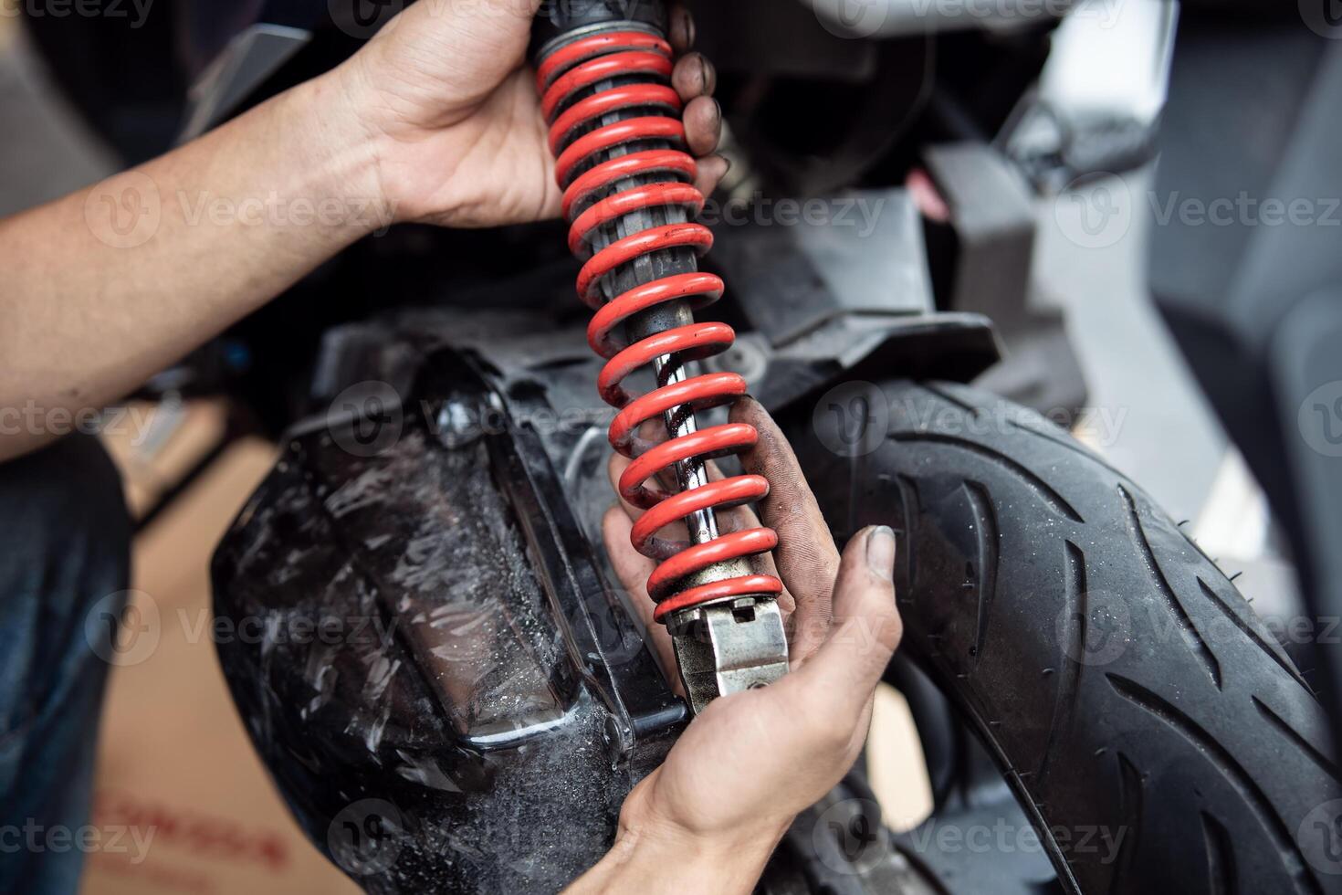 Motorcycle mechanic check and change rear Shock Absorbers motorcycle at motorcycle garage, Damaged Struts and fluid leaks among struts and shocks ,repair, maintenance and service concept photo