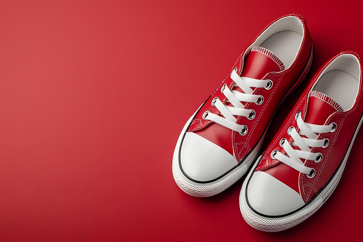 A Pair of Classic Red Canvas Sneakers on a Red Background. Perfect for fashion, retail, or lifestyle projects. photo