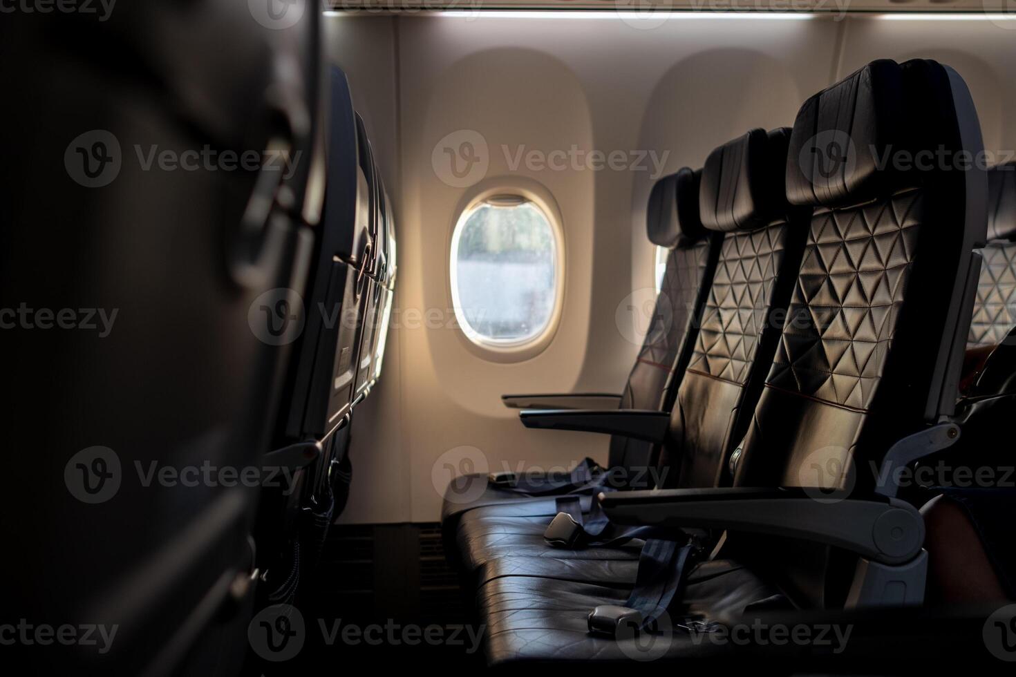 Empty Airplane Seats With a View of Clouds Outside the Window During a Flight at Sunset photo