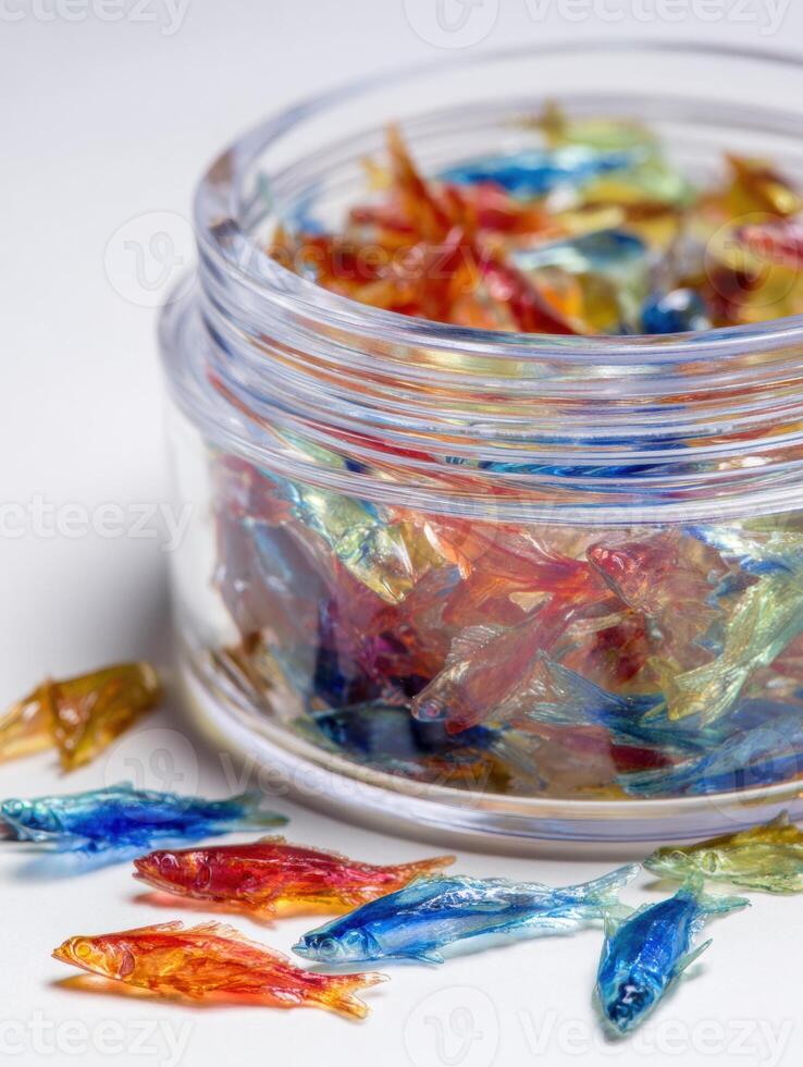 Colorful Fish Flakes in a Clear Container on a Bright Surface With Space Left Open for Additional Elements photo
