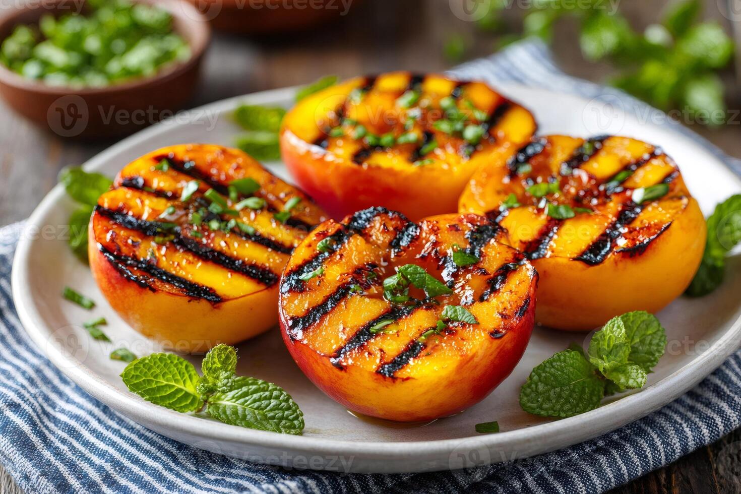 Delicious grilled peach halves garnished with fresh mint and chives photo