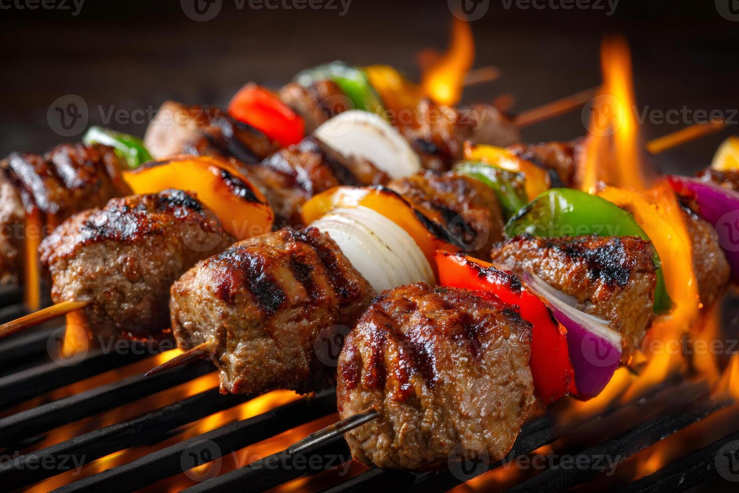Meat and vegetable skewers grilling on a barbecue with flames photo