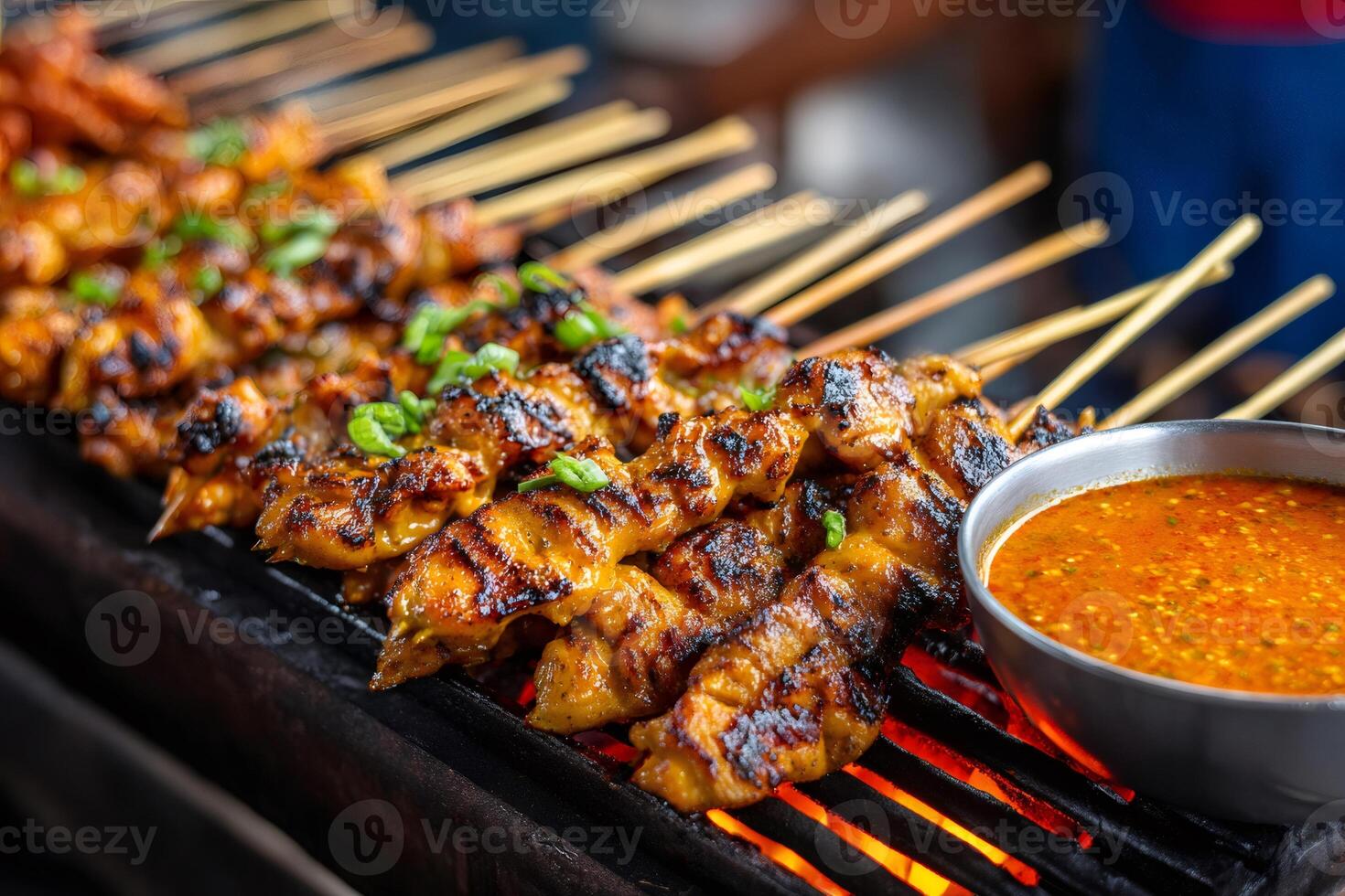 Delicious chicken satay grilling with spicy peanut sauce. photo