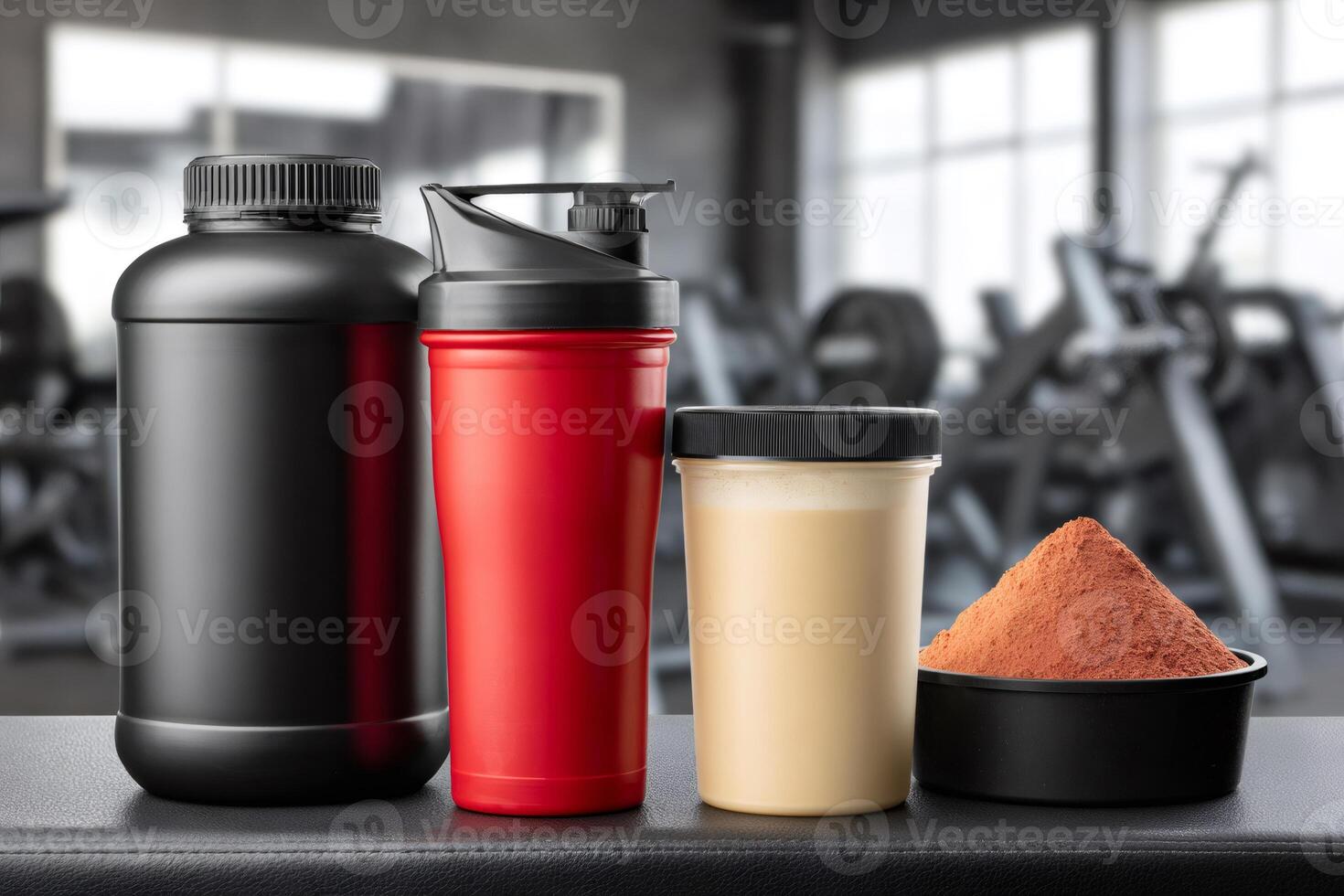Protein powder, shaker, ready made protein shake and jar standing on bench in gym photo
