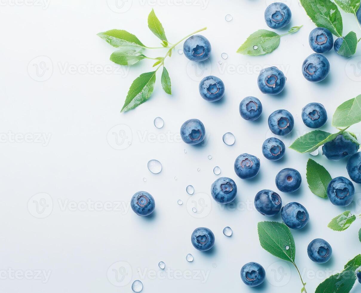 Fresh blueberries scattered on a light blue surface photo