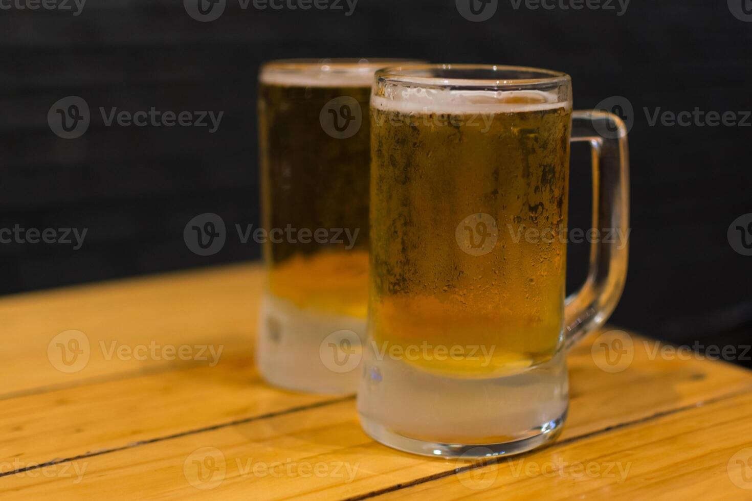 Two mugs of beer on a table photo