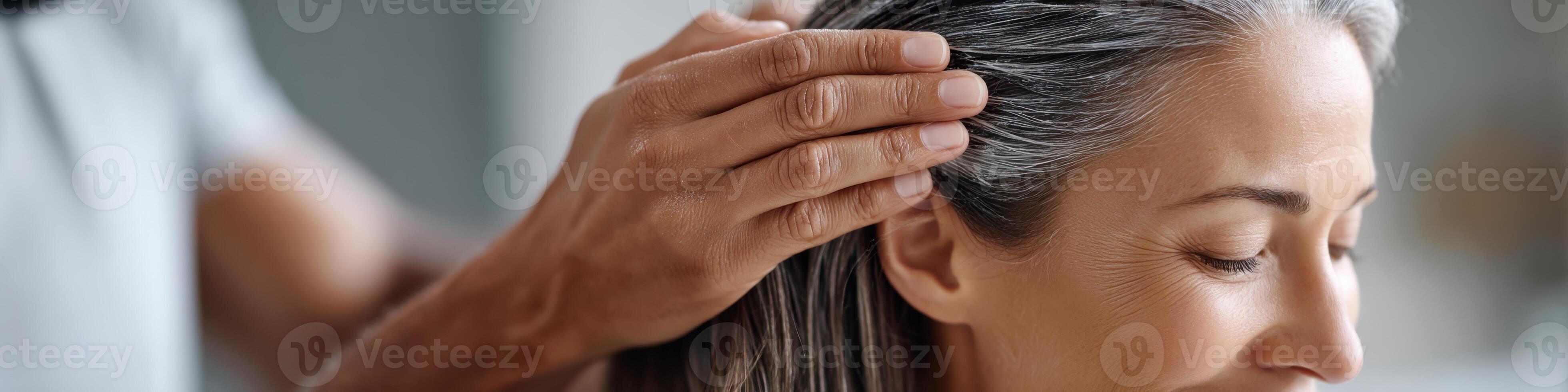 Hands applying scalp treatment for itch relief in a light-filled room with calming atmosphere photo