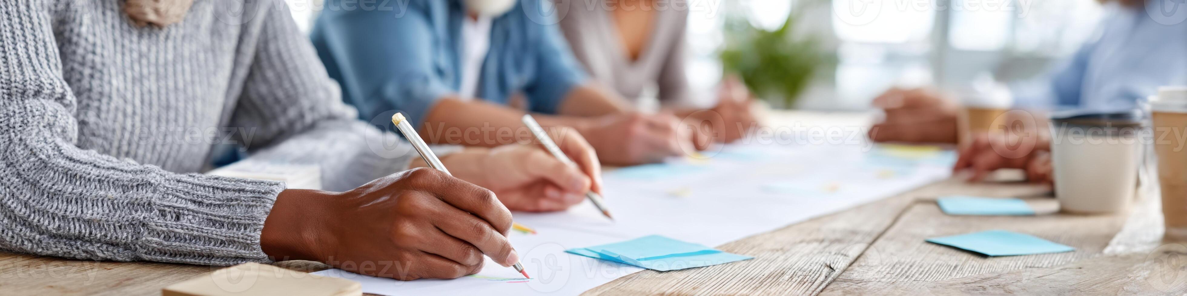Diverse hands engaged in creative preparation of teaching materials in a collaborative learning space photo