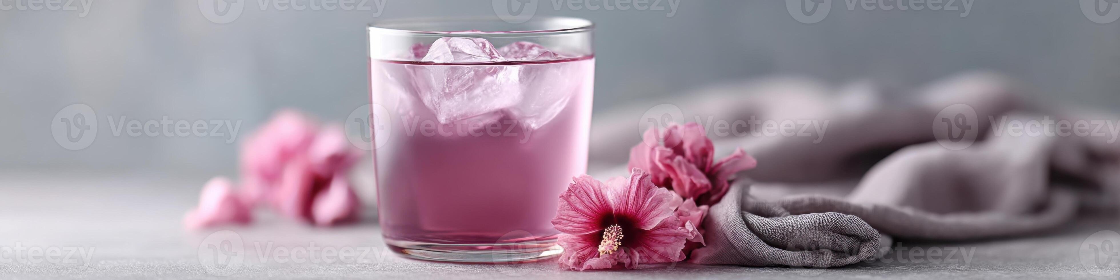 Refreshing hibiscus tea served in a glass with ice and dried flowers on a light background photo