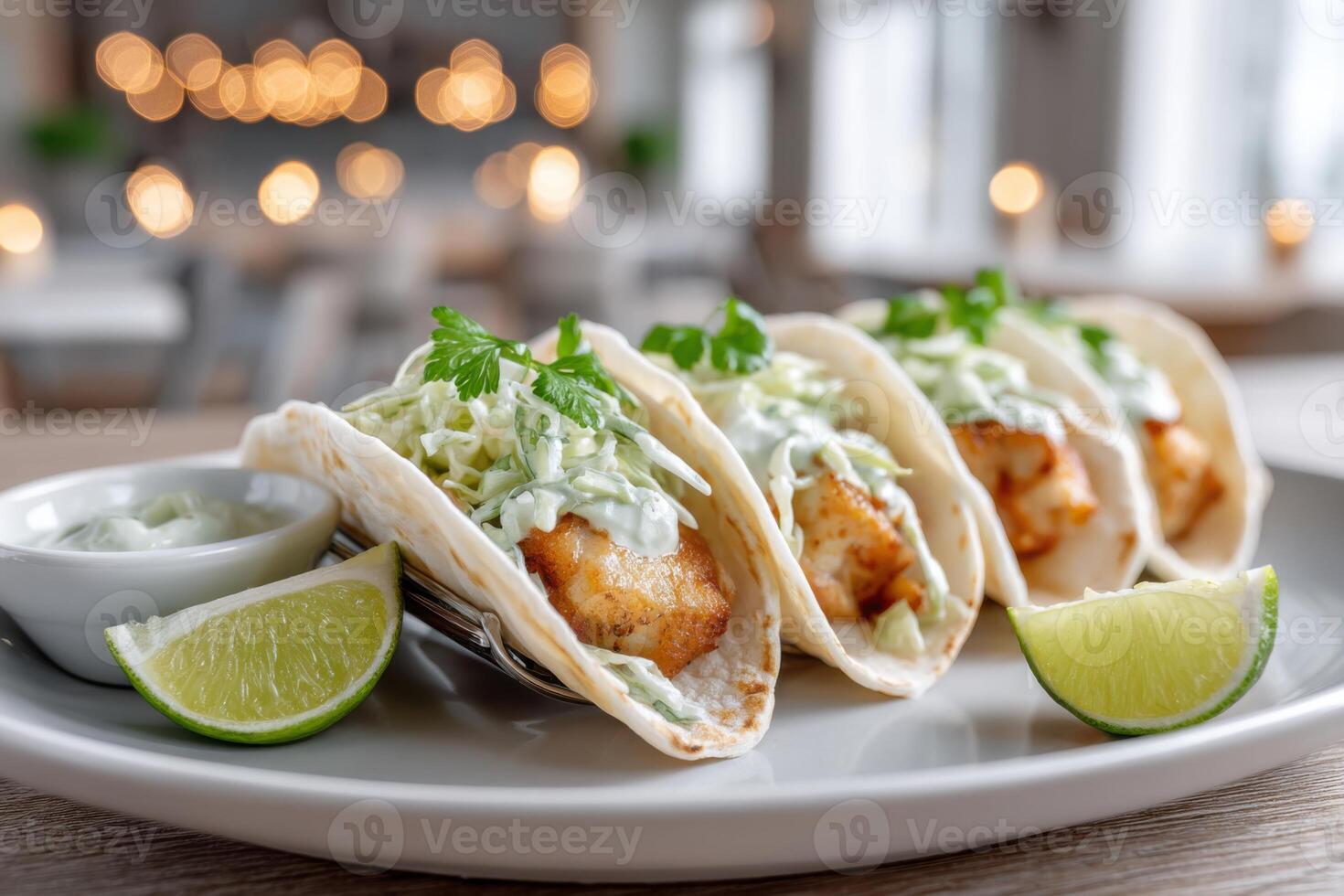 Delicious fish tacos served with fresh cabbage slaw and lime wedges in a modern restaurant setting photo