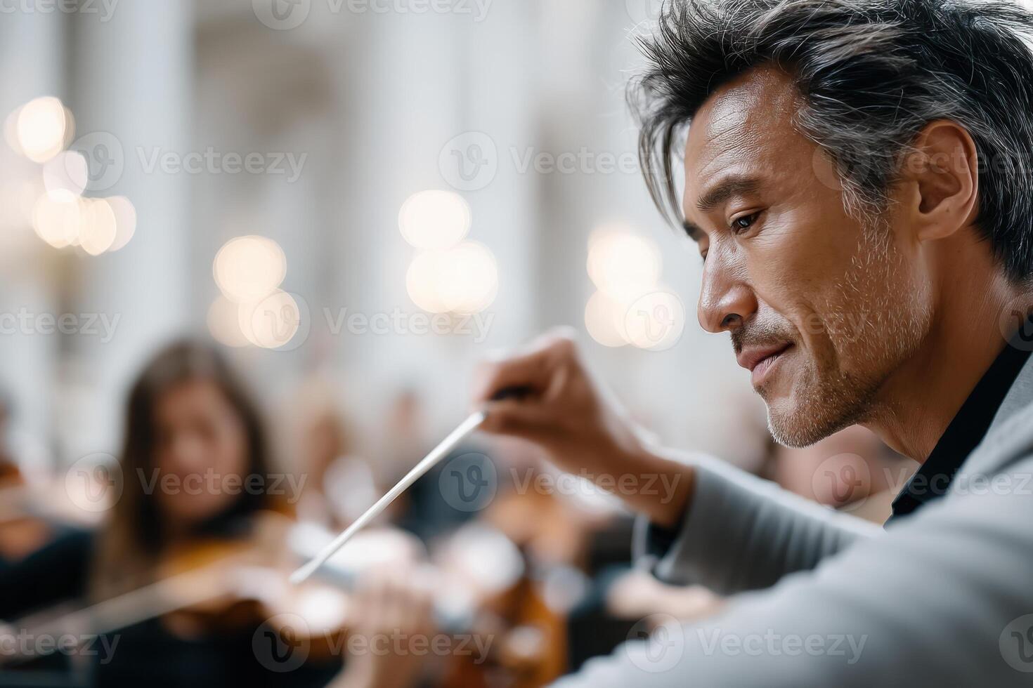 Dynamic conductor leads an orchestra in a captivating performance at a grand venue photo