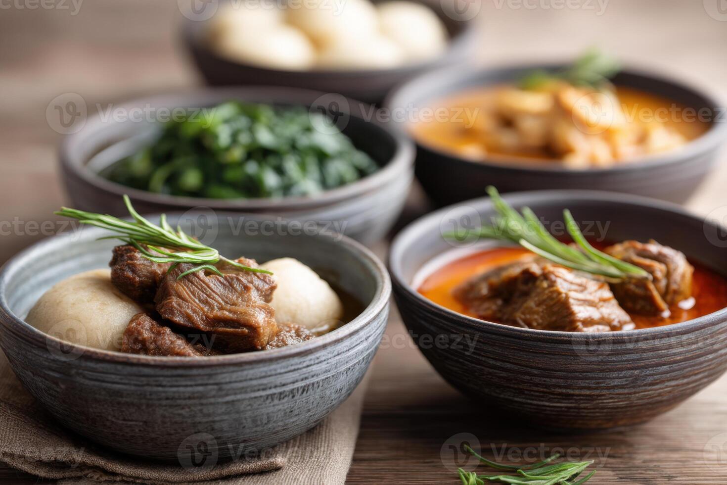 Delightful fufu served with an array of colorful stews on a rustic wooden table photo