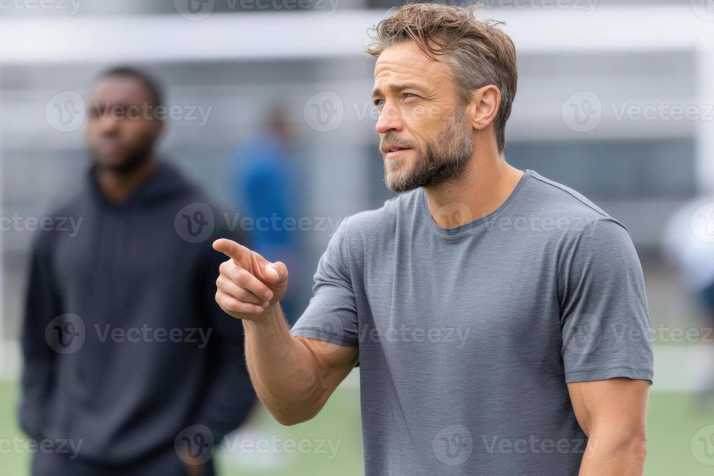 Dynamic sports instructor passionately guides athletes on skill development during a training session photo