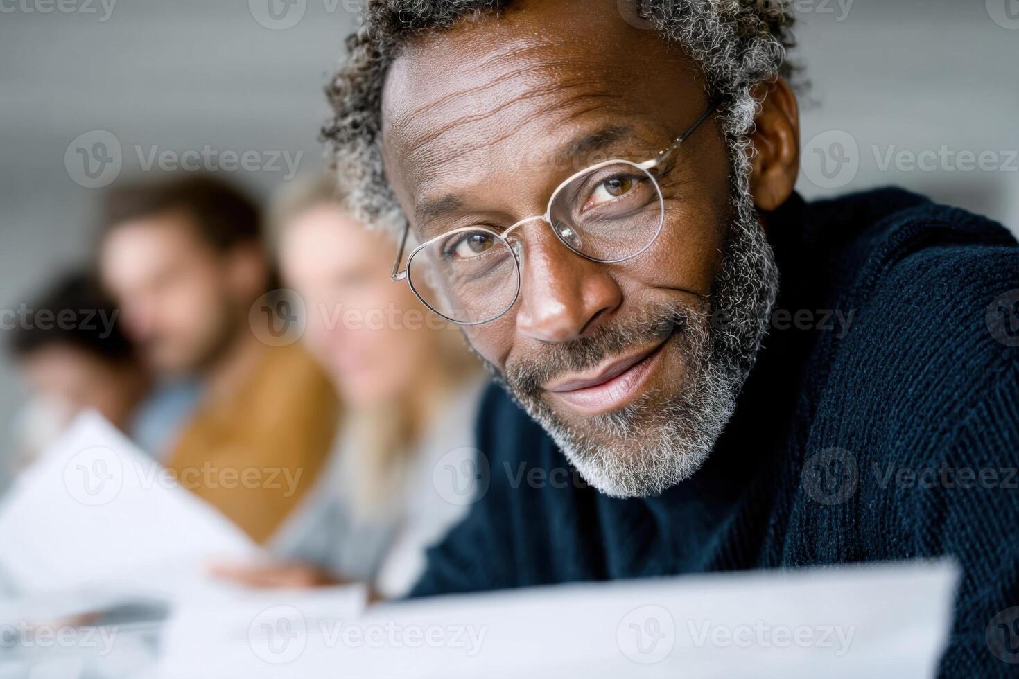 Middle-aged Black man reviewing contracts with clients in colorful office setting photo