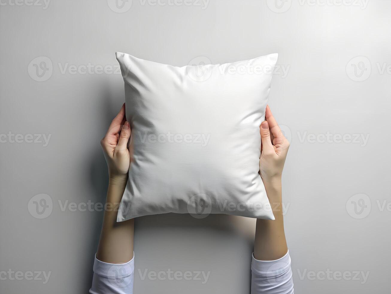 a person holding a white pillow on a gray background photo