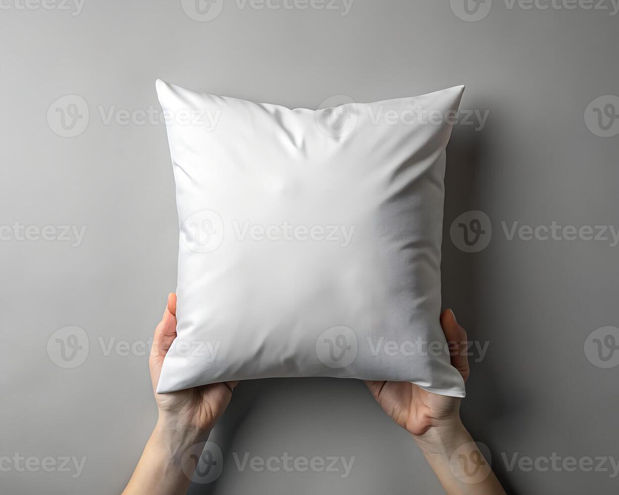 Overhead Shot of Hands Holding a Blank White Square Pillow Against a Grey Background photo