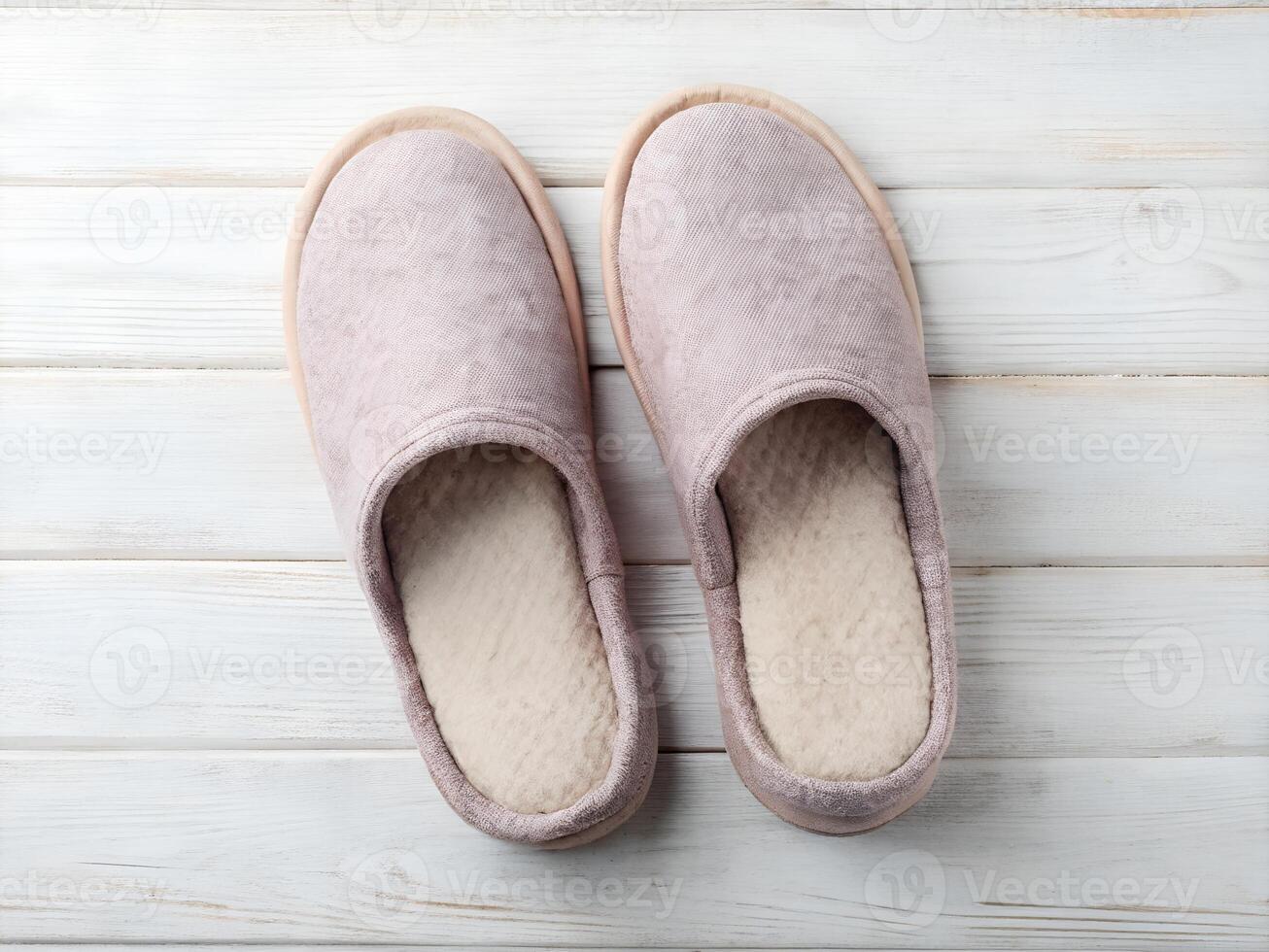 Pair of Pink Fuzzy Slippers on White Wooden Background photo