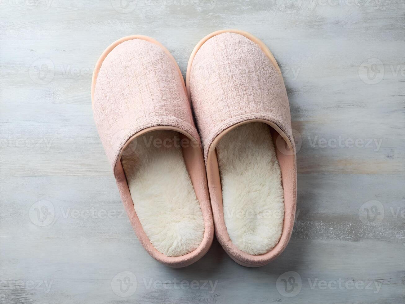 Pair of Soft Pink Fluffy Slippers on a Gray Textured Background photo