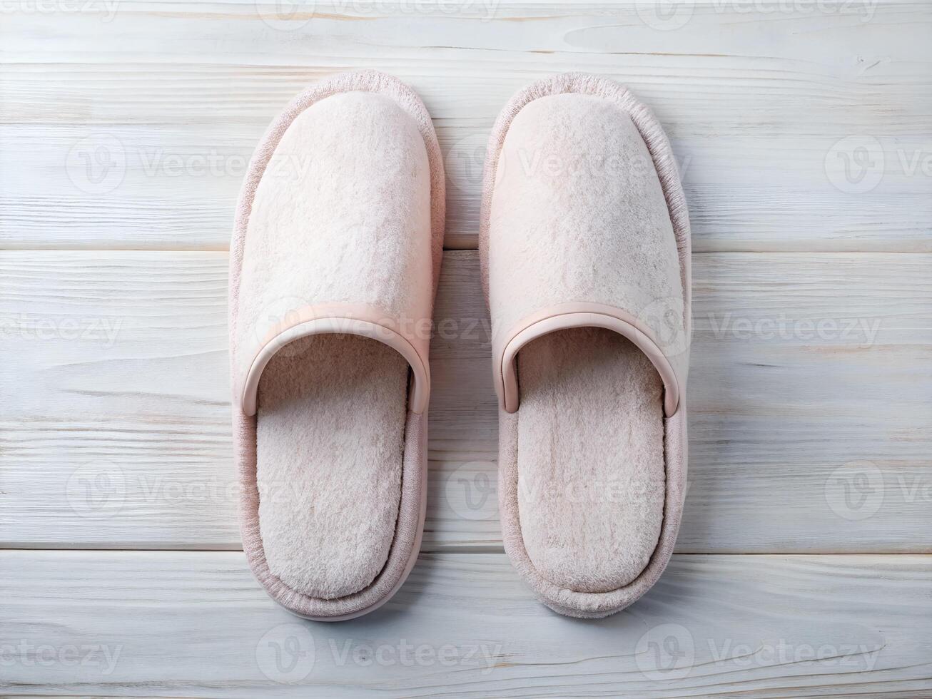 Pair of Light Pink Fluffy Slippers on White Wooden Floor photo