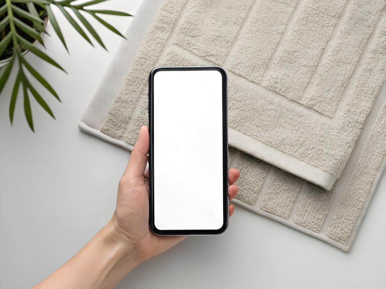 Woman's Hand Holding Smartphone with Blank Screen, Minimalist White Background photo