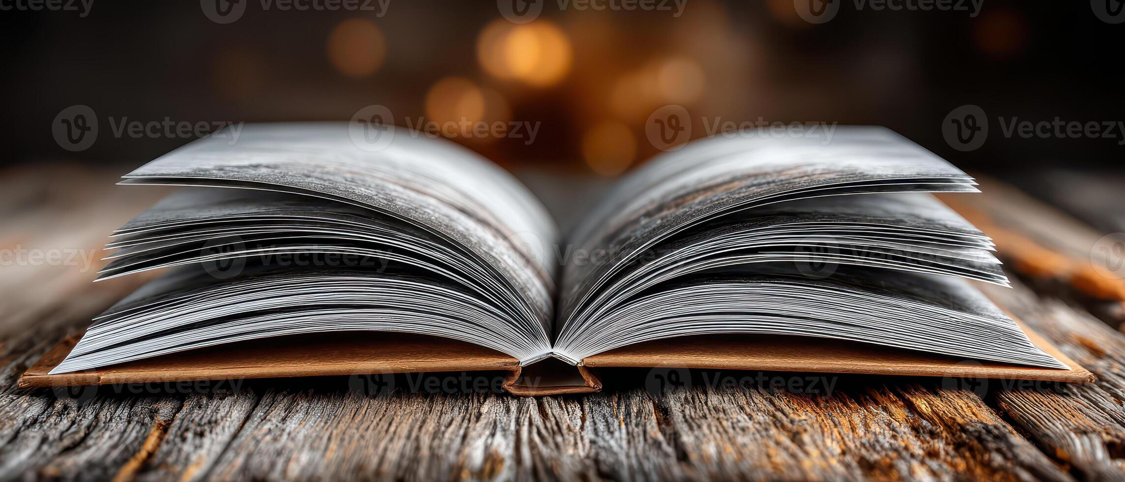 Open book on wooden table with warm background photo