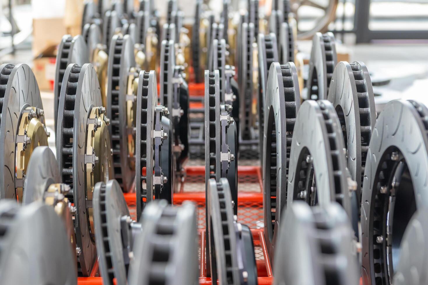 A large number of brake discs are stacked on a shelf photo