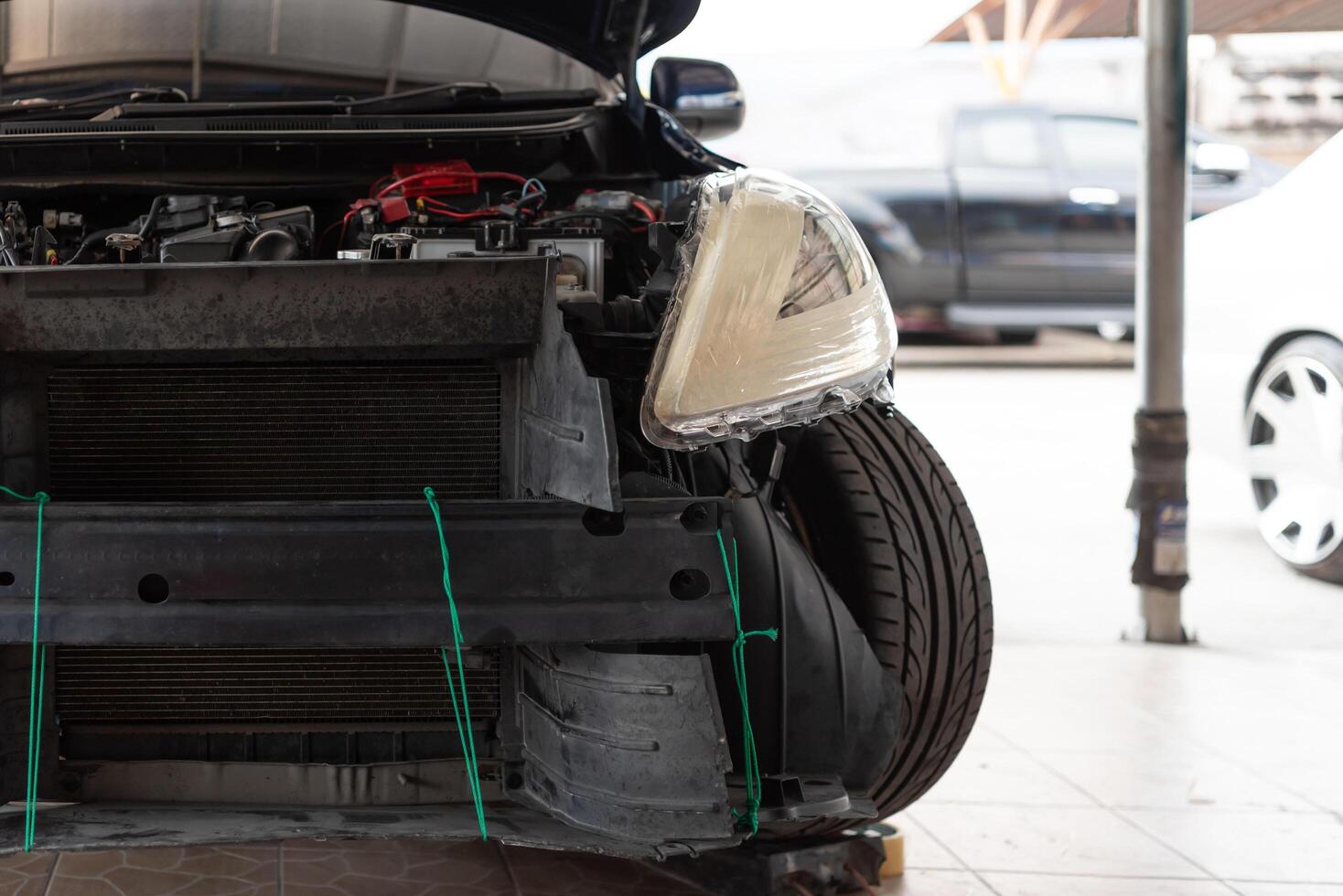 A car with its front end damaged and its engine removed photo