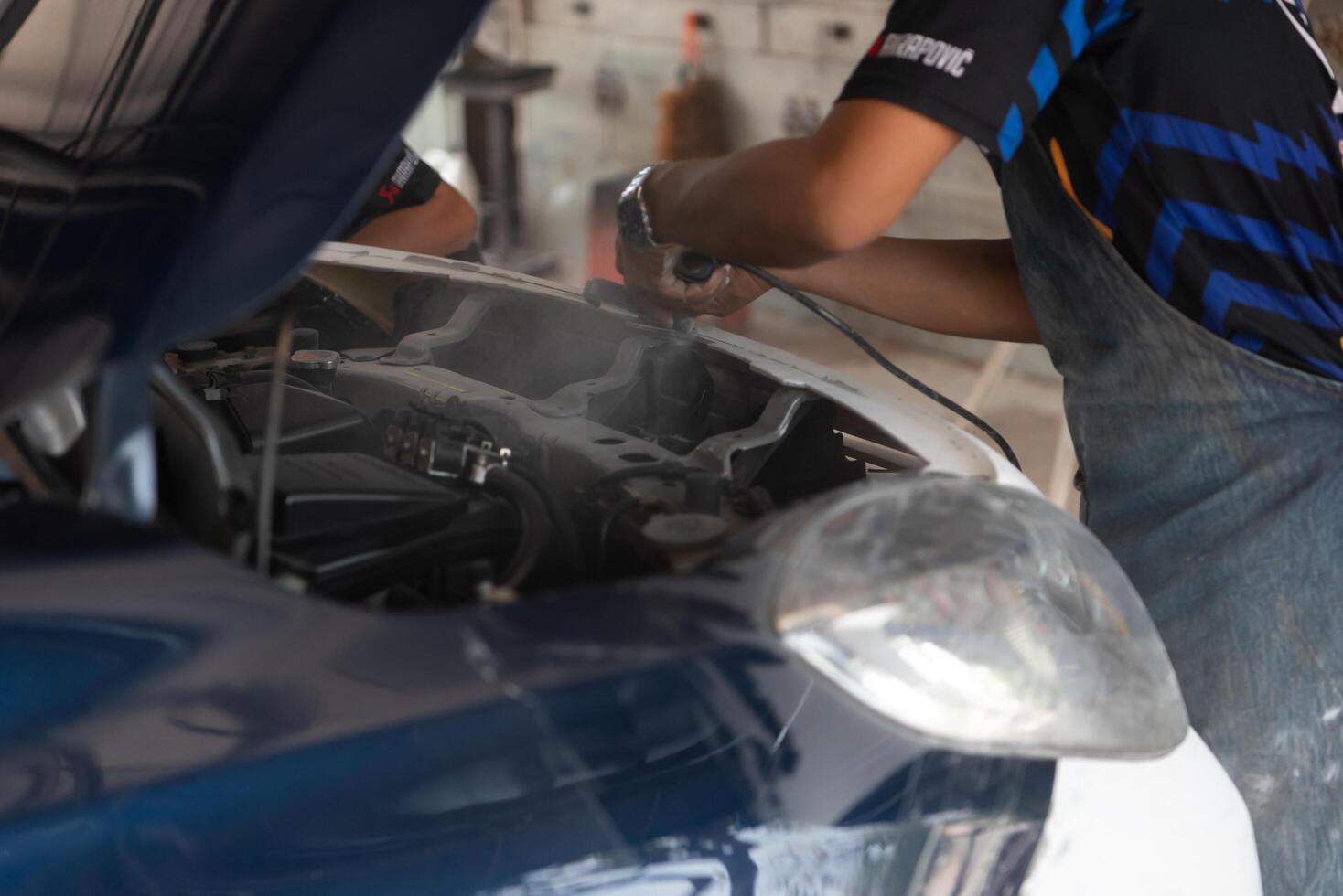A man is working on a car in a garage photo