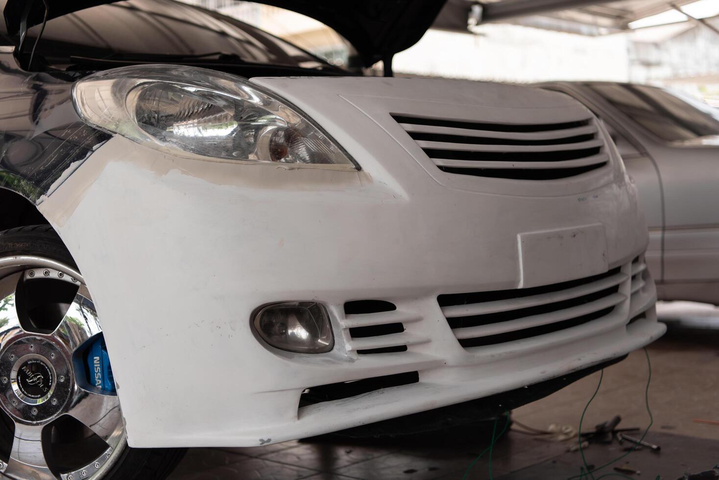 A white car with a hood up photo