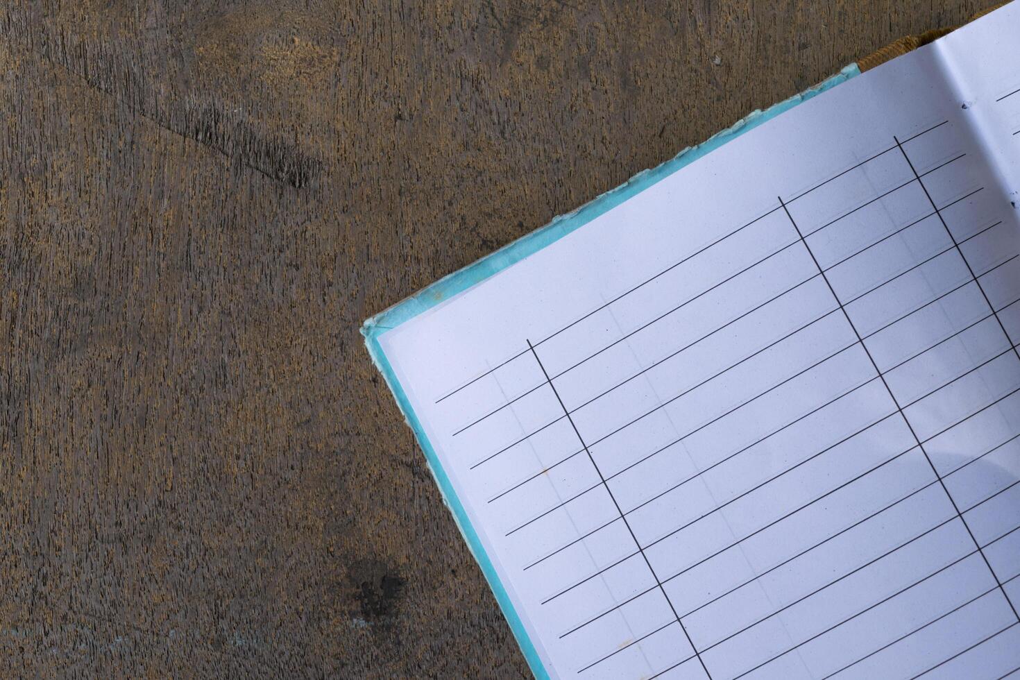 A notebook with a pen sitting on top of a wooden table photo