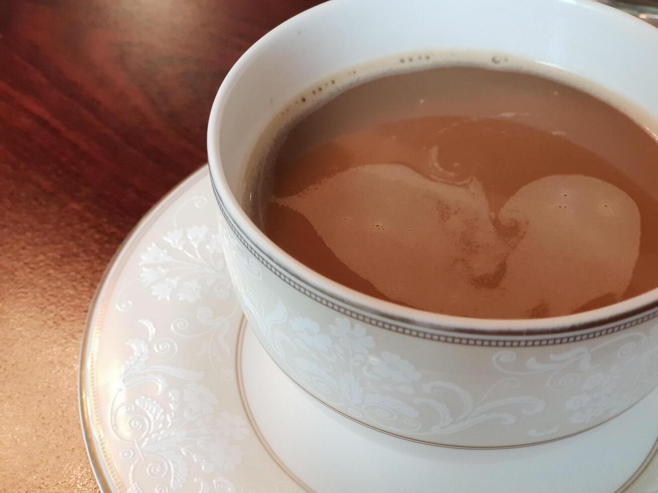 A cup of coffee with a heart shape in it photo