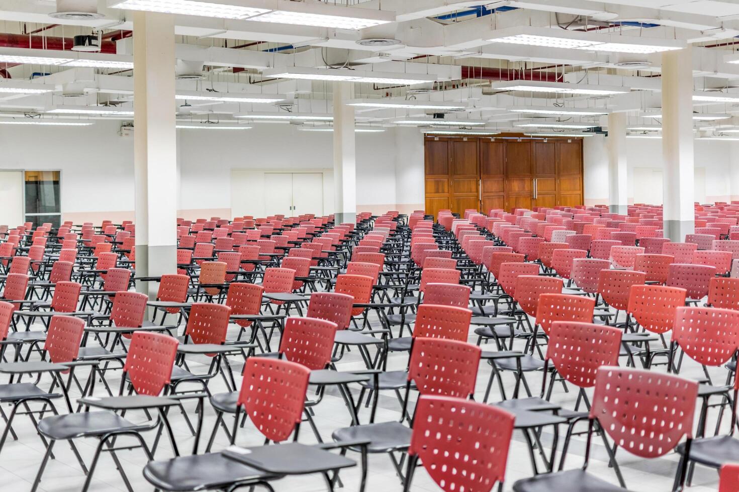 A large room with rows of chairs and tables photo