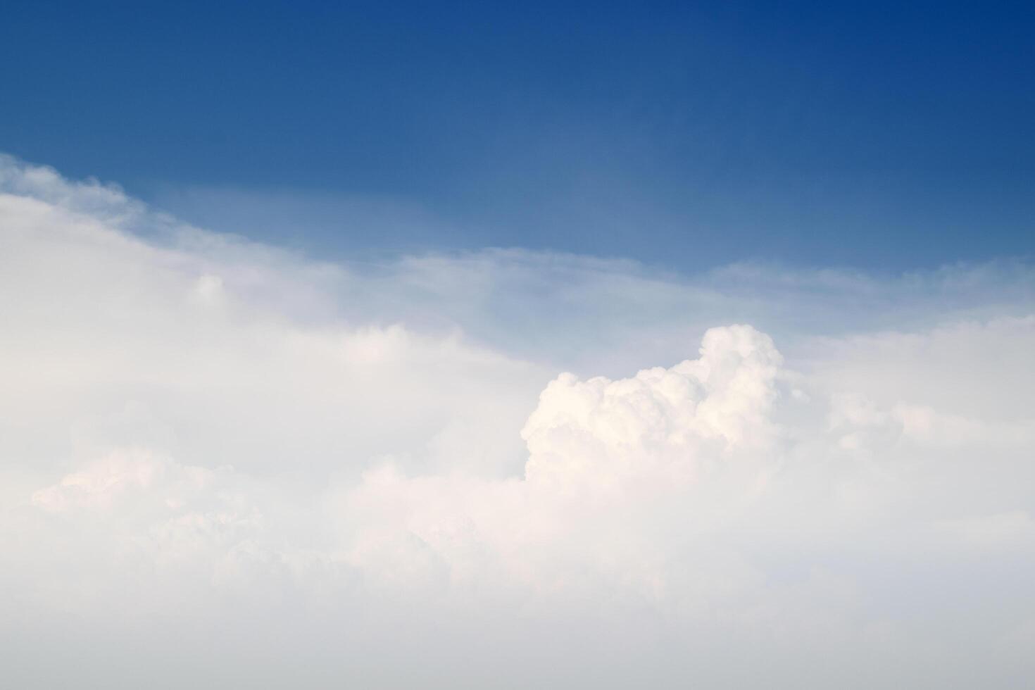 A plane flying in the sky with clouds in the background photo