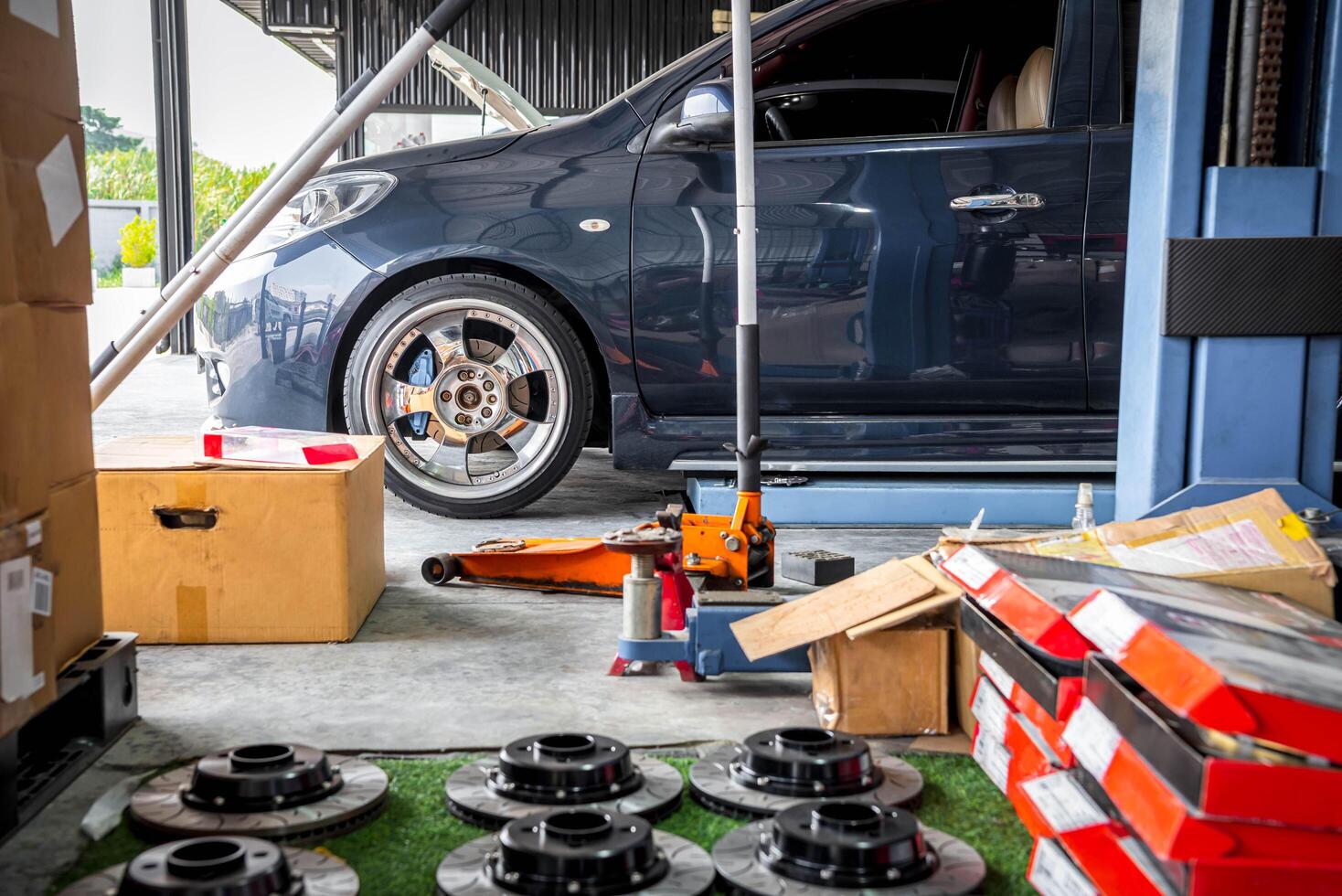A car is sitting in a garage with a box of tires photo
