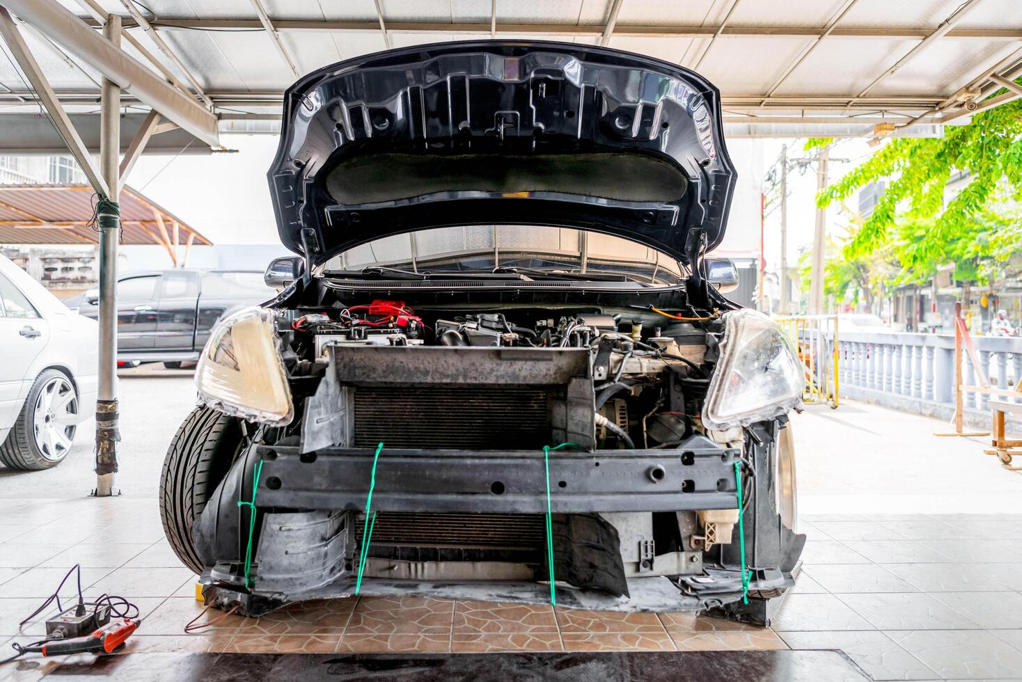 A car with its hood open and the engine on the ground photo