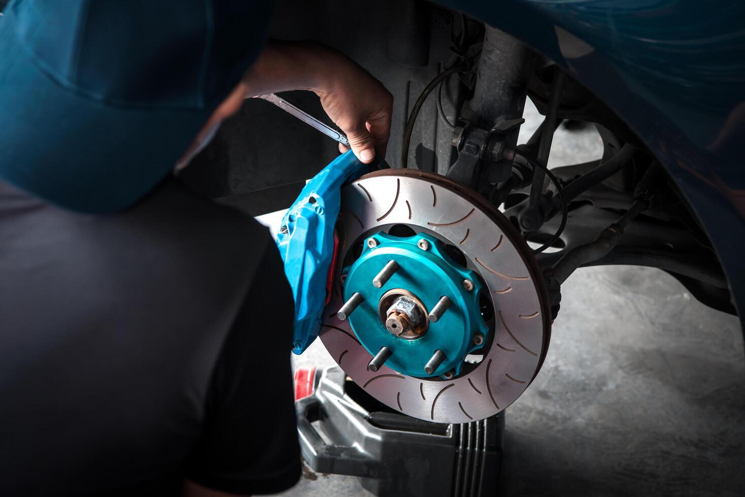 A man is fixing a brake on a car photo