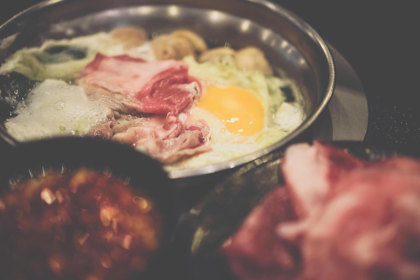 A pan with meat, eggs and vegetables on it photo