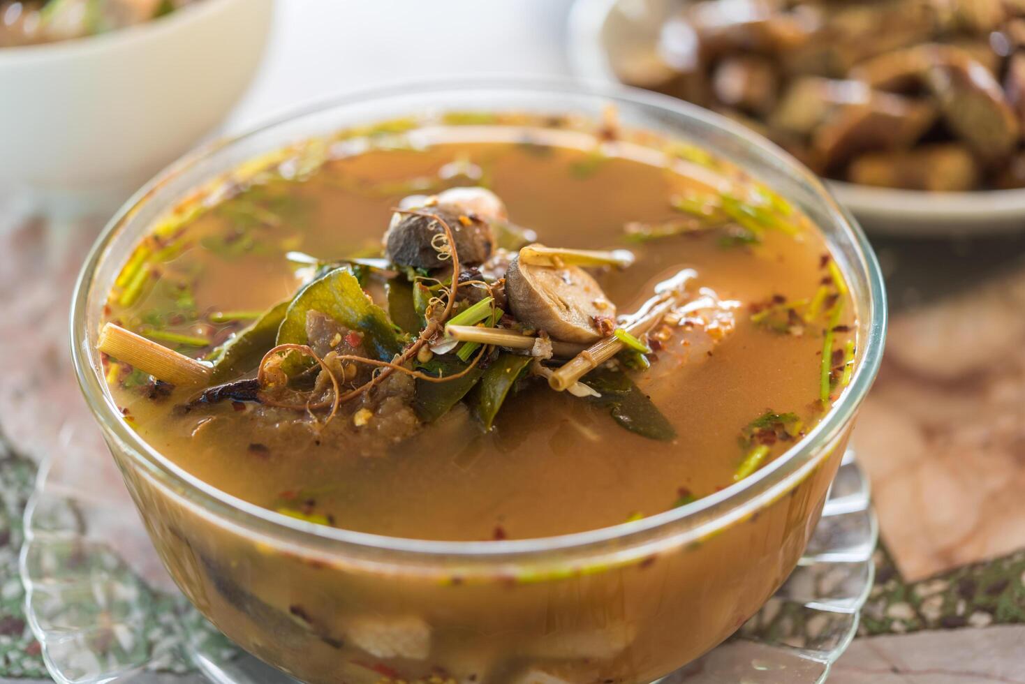 A bowl of soup with a bowl of mushrooms photo