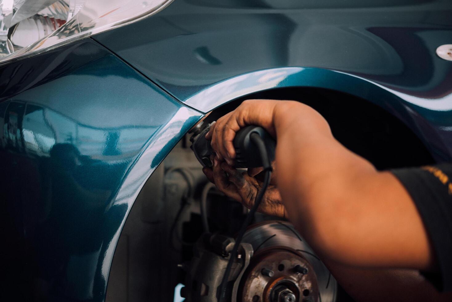 A man is repairing a car's wheel photo