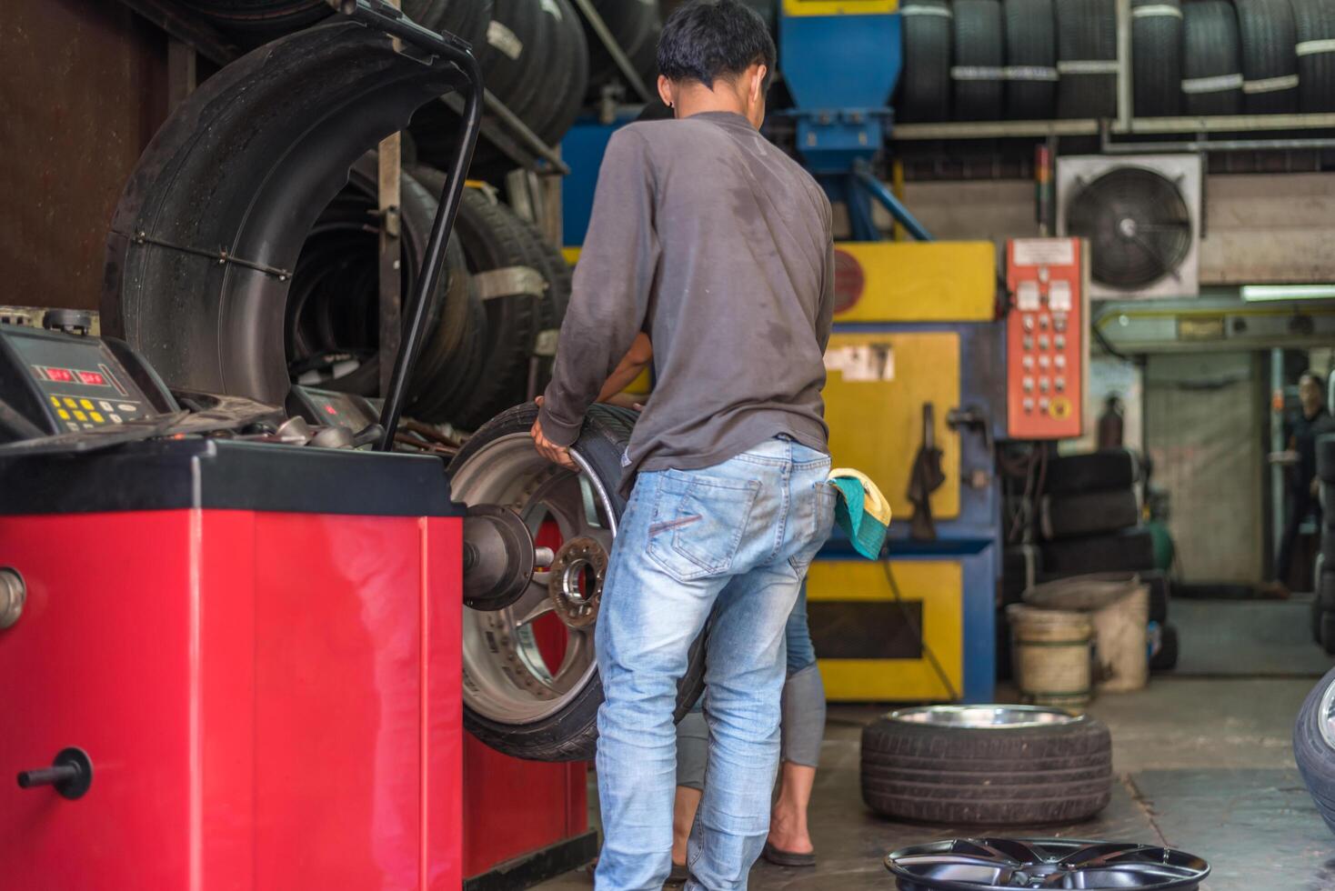 A man is working on a tire in a garage photo