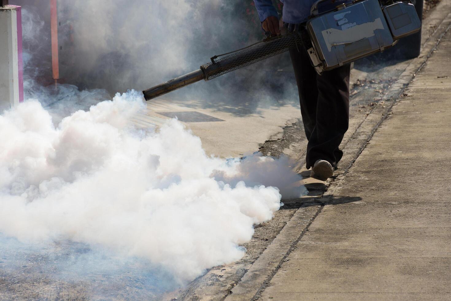 A man spraying a white substance on a sidewalk photo