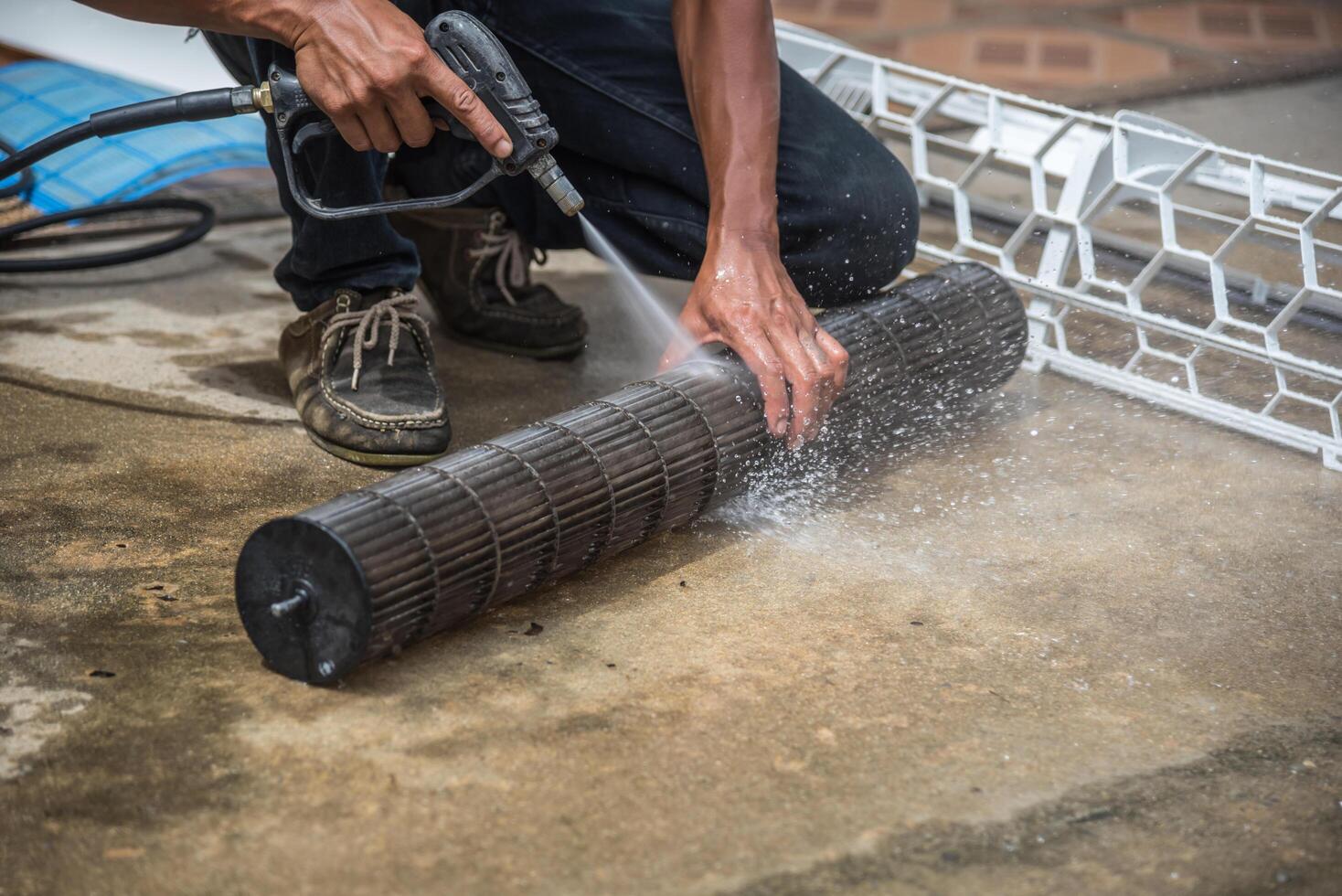 A man is using a hose to clean a concrete floor photo