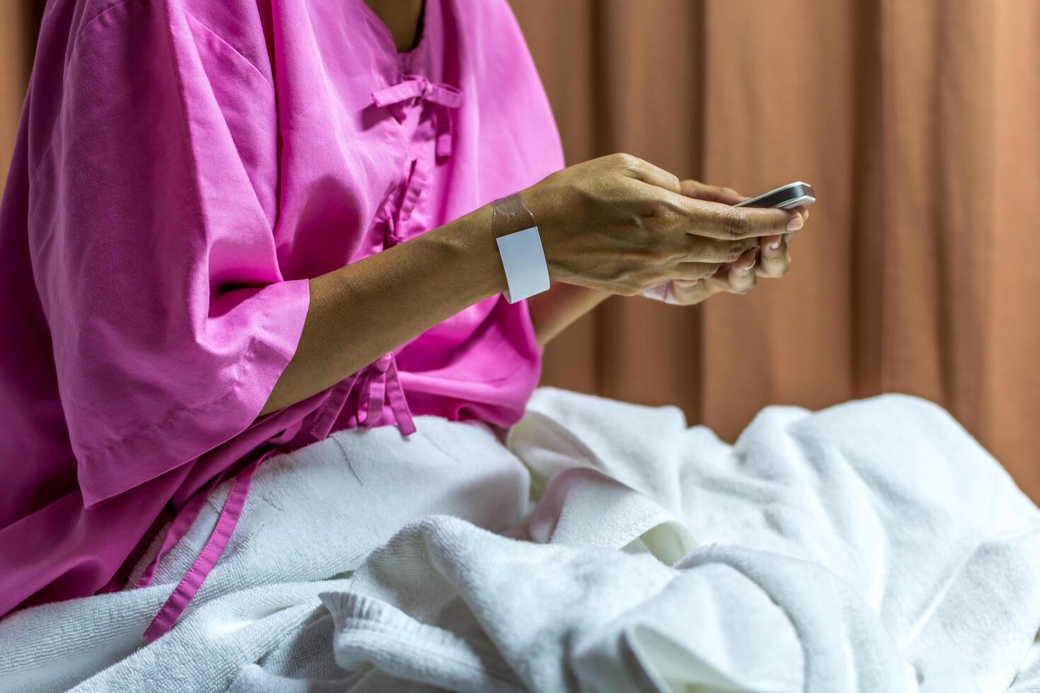 Patient woman using smartphone on bed photo