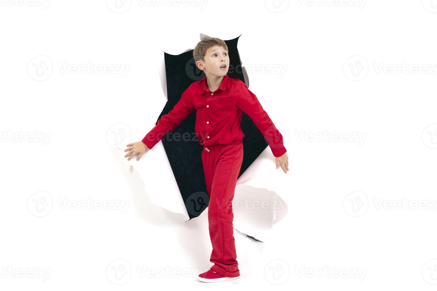 A child from a hole in paper. Boy shows cardboard. photo