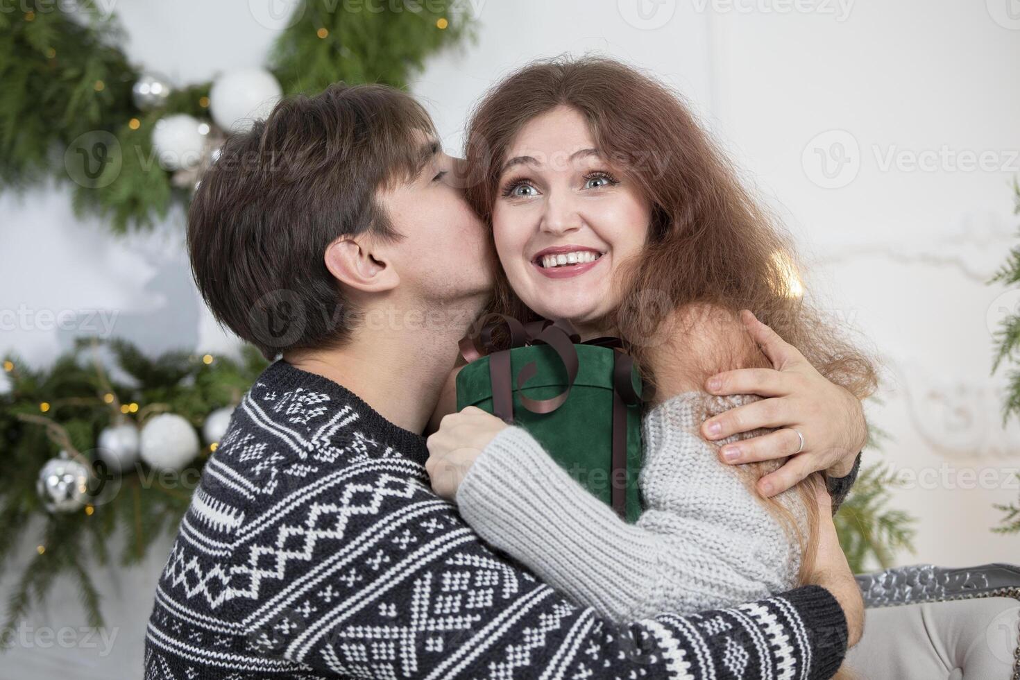 A man gives a woman a Christmas present. Husband and wife in the New Year holidays. photo