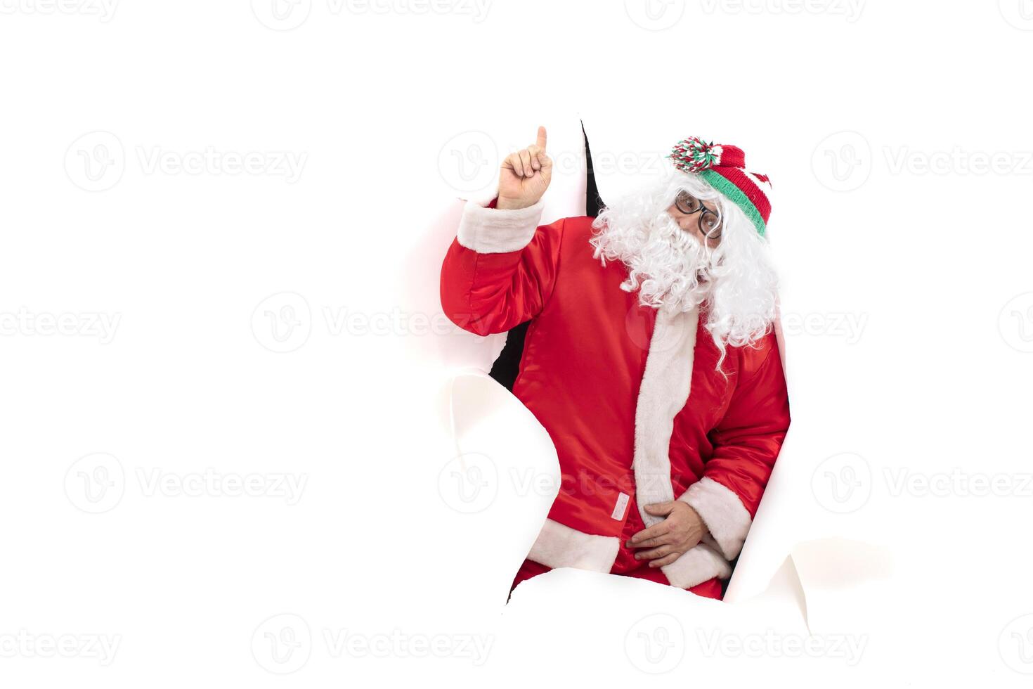 Santa Claus from a hole in paper. Christmas Holidays. photo
