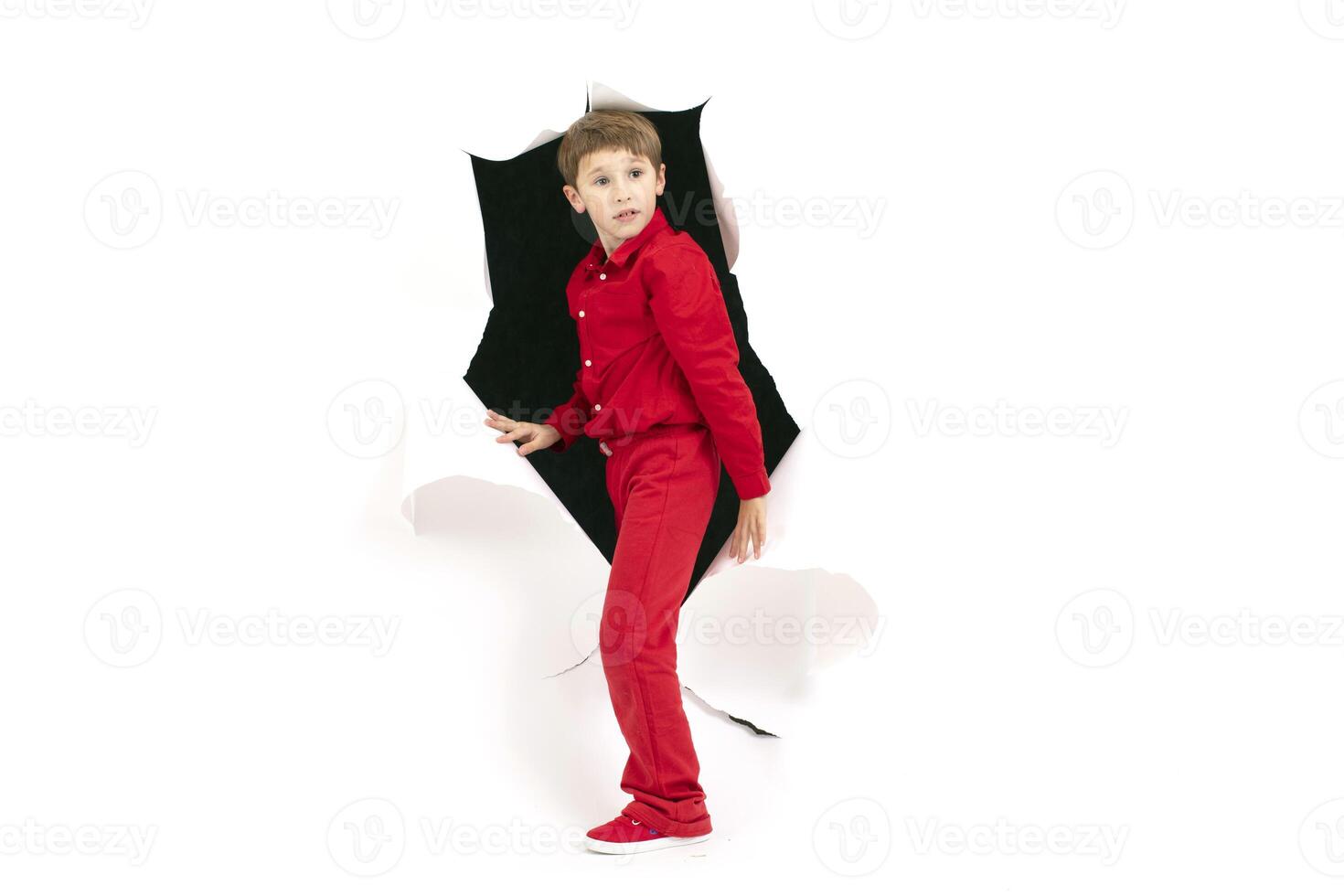 A child from a hole in paper. Cardboard show boy photo