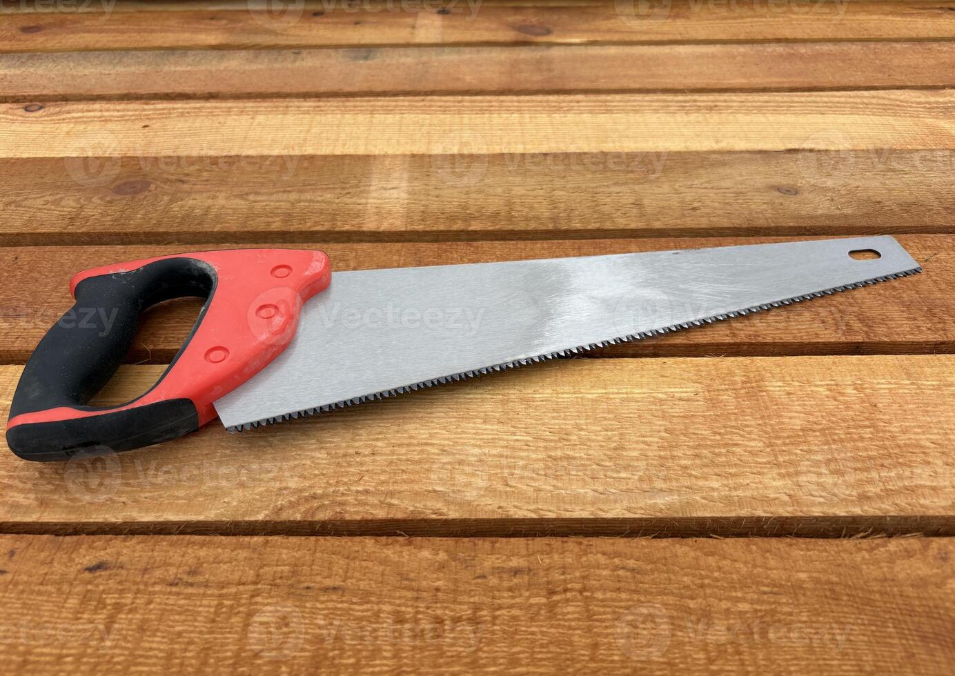 A wood saw lies on a stack of new lumber at a construction site or sawmill. photo